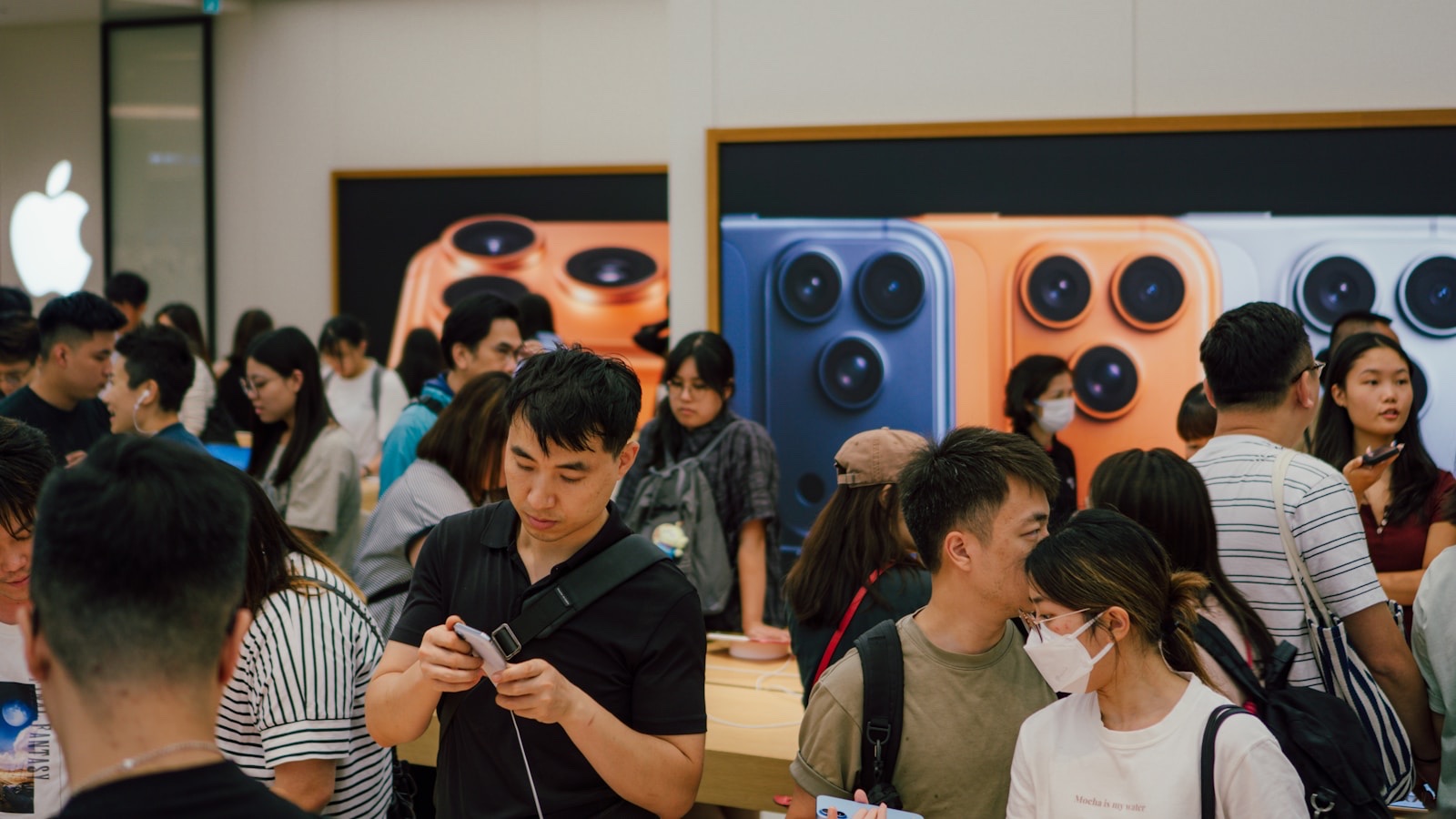 値上げで高くなったiPhoneを店頭で見比べる人