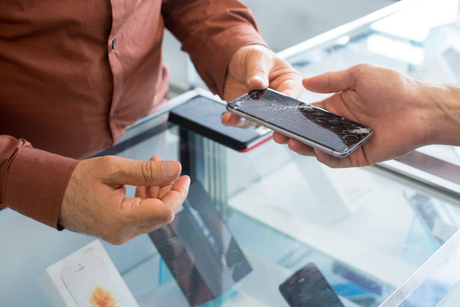 店頭で複数のスマートフォンを比較しながら選んでいる様子