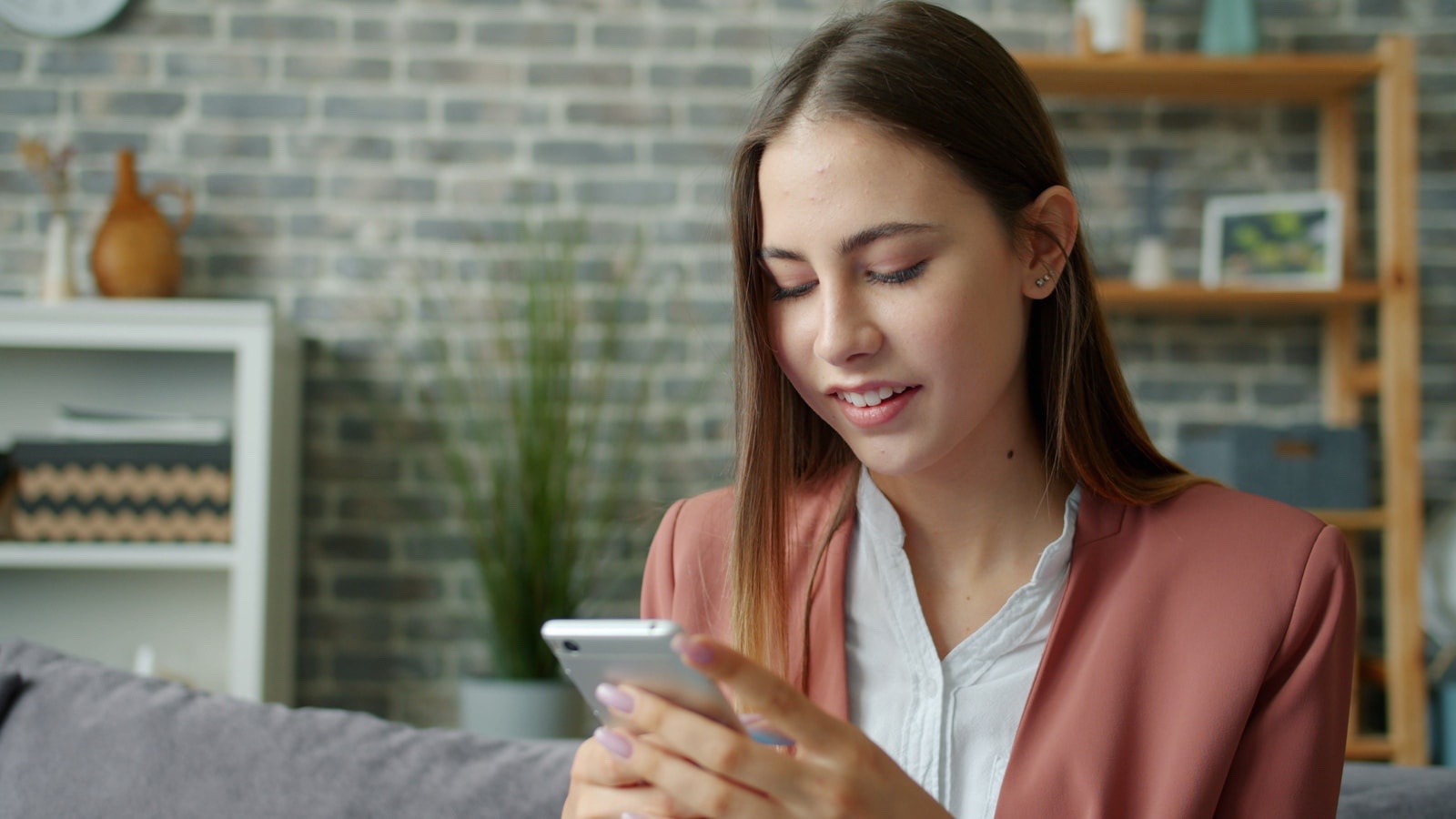 スマホを操作しながら微笑む女性