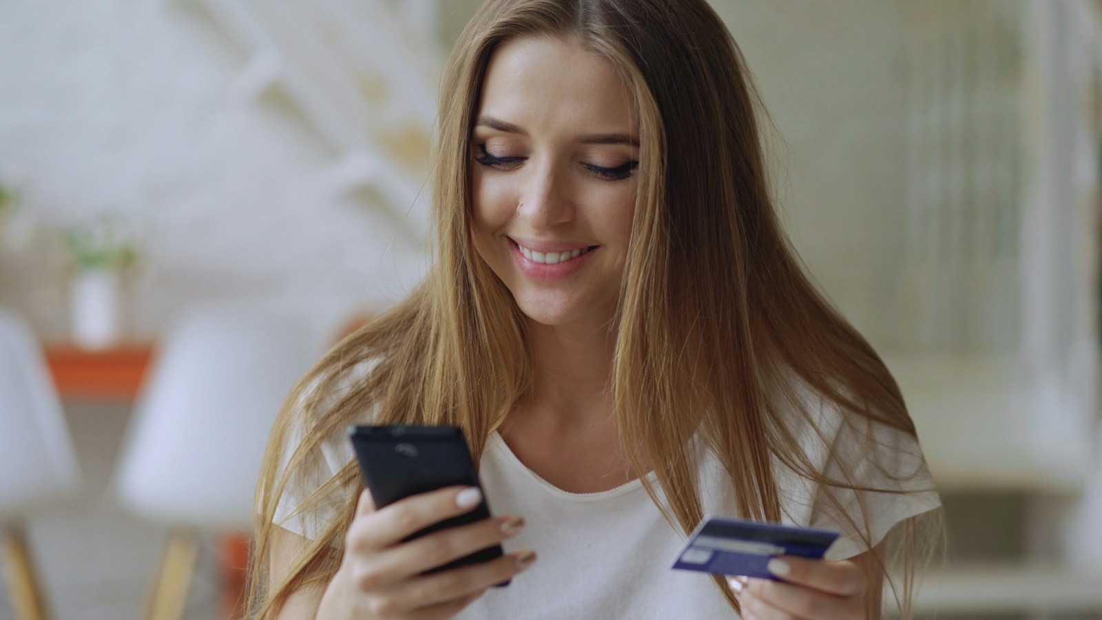 スマートフォンで価格比較ページを確認する人物