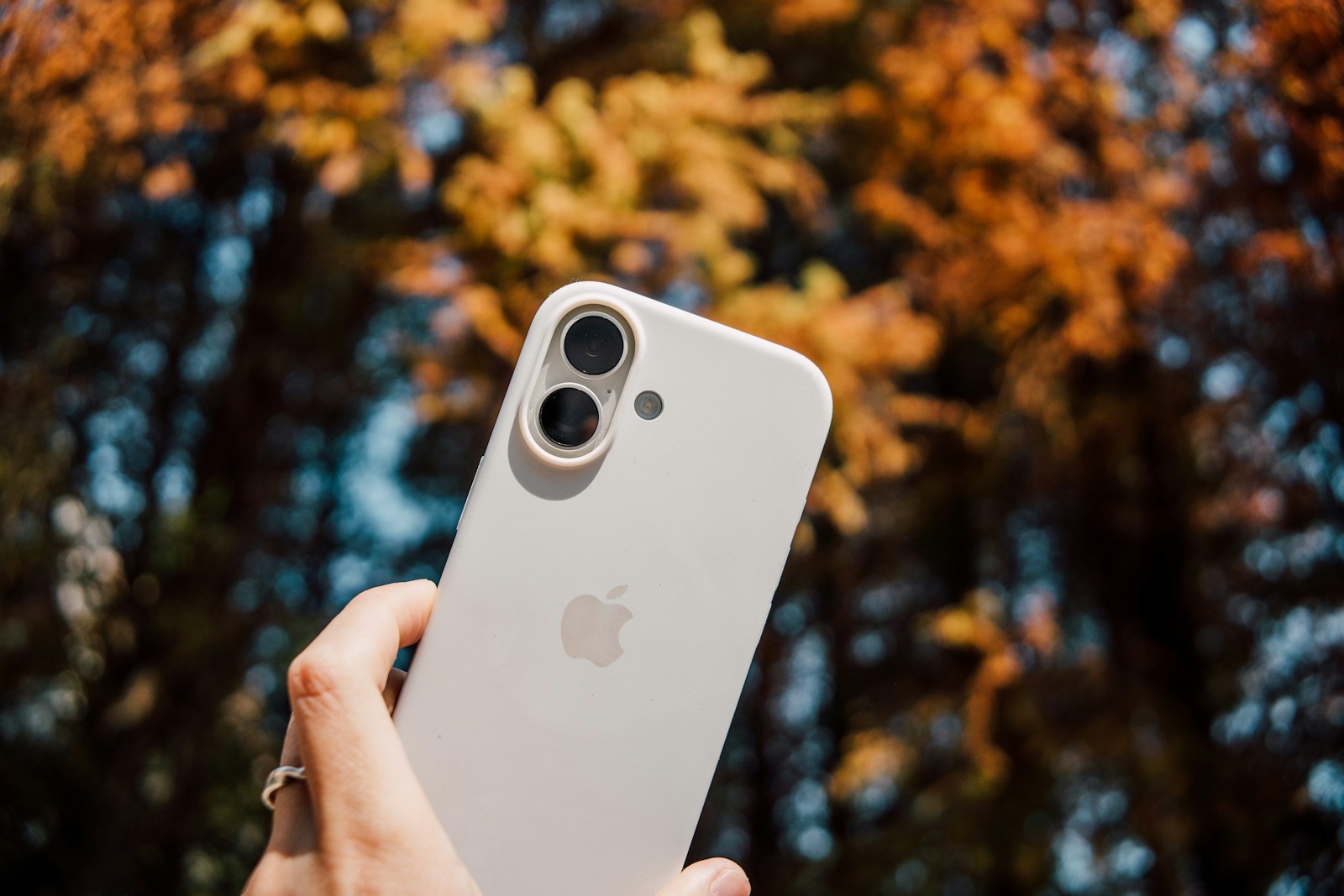 白いiPhoneを手に持って操作している様子