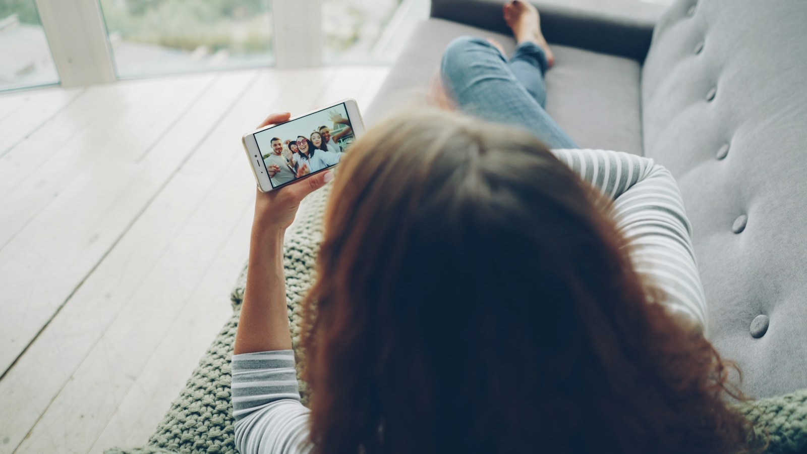リビングでスマホの動画配信アプリを見ながらくつろぐ様子